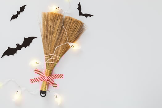 Halloween composition with taping broom, black bats and light garland with ghosts and copy space photo