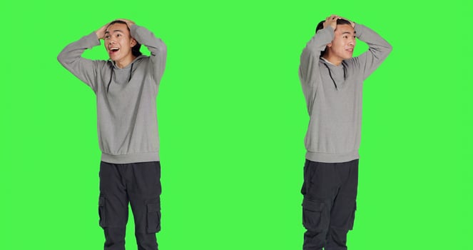 Adult having pleased reaction in studio after seeing something, saying wow and being surprised by it. Asian person in shock admiring wonderful thing, feeling content and optimistic. photo