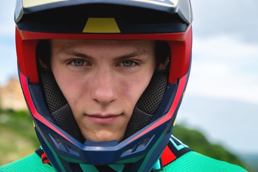 Close-up portrait of a confident handsome young athlete wearing a stylish helmet looking at the camera with eyes full of determination photo