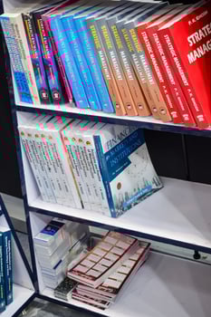 New Delhi, India, February 17 2024 - Variety of Books on shelf inside a book-stall at Delhi International Book Fair, Selection of books on display in Annual Book Fair at Bharat Mandapam complex photo