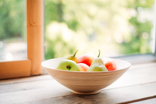 apples and pears on a windowsill in a wooden plate. summer and fresh fruits photo
