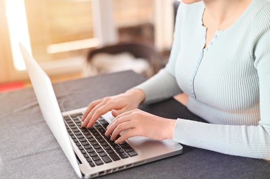 A woman uses a laptop, searches on the Internet, views information. workplace at home. remote work at home photo