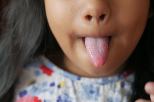 child shows his tongue closeup photo