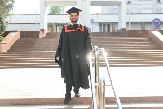 Handsome indian graduate in graduation glow with diploma photo