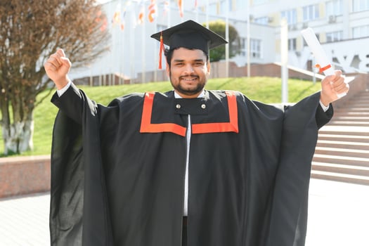 Portrait of happy man, graduation or student in university campus photo