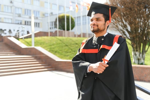 Handsome indian graduate in graduation glow with diploma photo