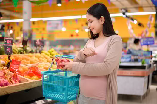 Beautiful pregnant woman shopping healthy food at grocery shop photo