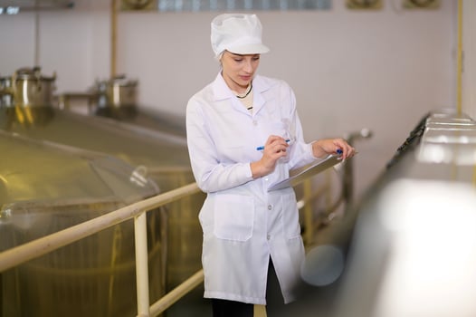 Professional winemaker controlling wine making process and quality at winery factory photo