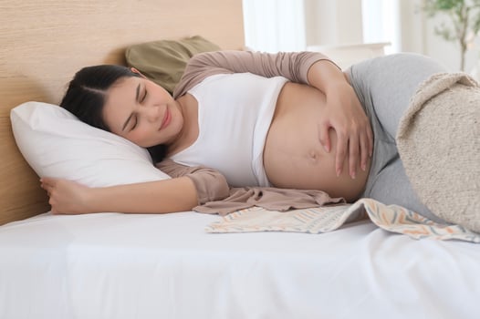 Pregnant woman feeling sick to her stomach, holding belly, having abdominal cramps, uncomfortable. photo