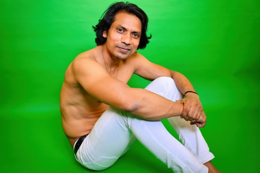 Shirtless man sitting with smile on floor photo
