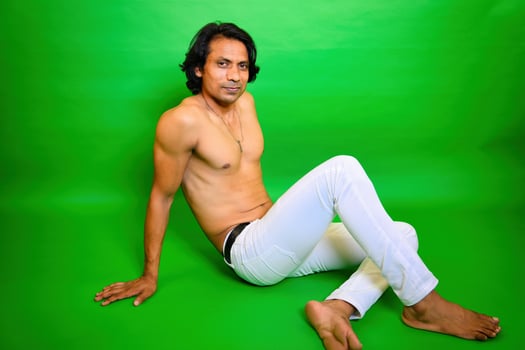 Smiling Shirtless man sitting on floor posing photo