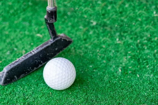 Golfer preparing on training putt with golf ball photo