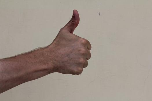 Closeup of male hand showing thumbs up sign photo