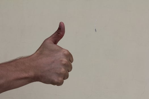 Closeup of male hand showing thumbs up sign photo