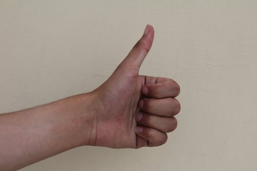 Closeup of male hand showing thumbs up sign photo