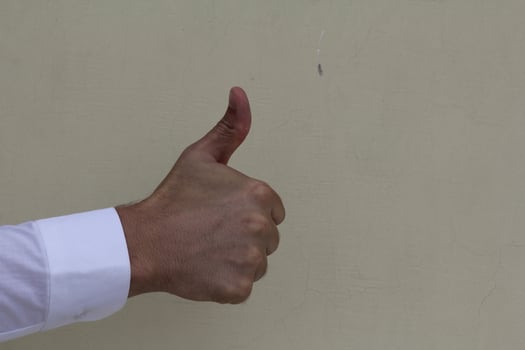 Closeup of male hand showing thumbs up sign photo