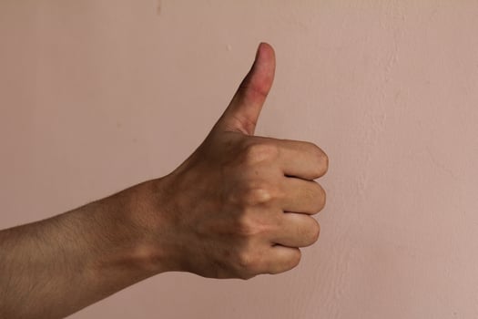 Closeup of male hand showing thumbs up sign photo