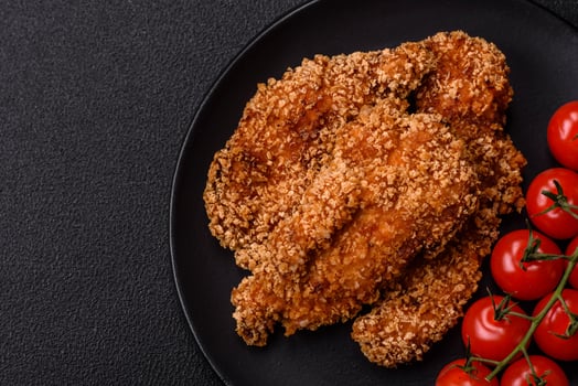 Delicious fresh crispy chicken nuggets on a dark concrete background photo