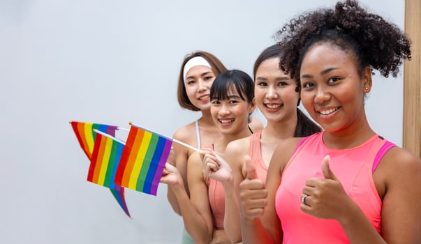Group of diversity woman in sport wear holding LGBTQ rainbow flag for pride month to promote equality and differences of homosexual and discrimination concept photo