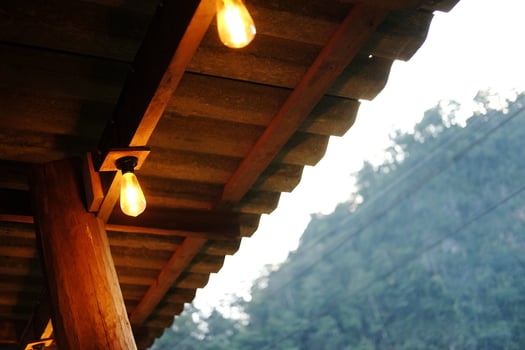 Light bulbs is hanging on wooden beam indoor of cafe and vintage house building photo