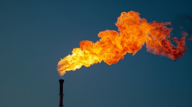 The serenity of a cloudless sky disturbed by the violent flames of a raging gas flare photo