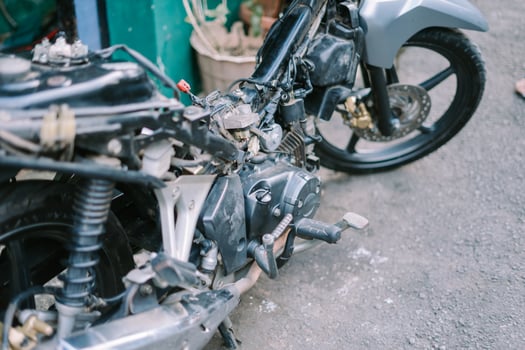 A motorcycle mechanic is checking a damaged engine photo