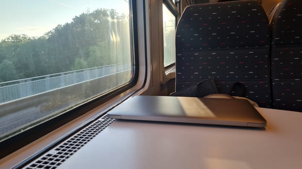 Working on the Go. Using a Laptop on a Train Journey with Scenic Views Outside the Window - Emphasizing Productive Travel and Efficient Transportation photo