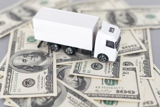 White toy truck lie on dollars, space for text. photo