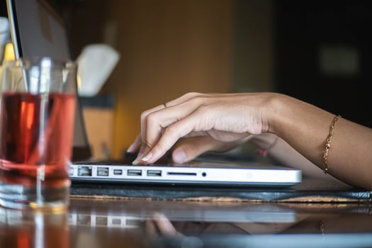 Hands Typing on Laptop with Refreshing Drink photo
