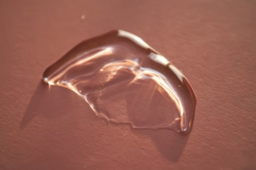 Beautiful volumetric drop of cosmetic product on a pink background. photo
