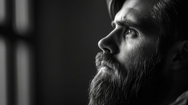 Moody black and white portrait of a bearded man, thoughtfully gazing into the distance photo