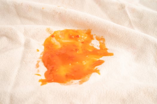 Dirty tomato sauce stain or ketchup on cloth to wash with washing powder, cleaning housework concept. photo