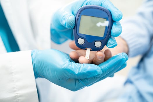 Doctor check diabetes from finger blood sugar level with finger lancet. photo
