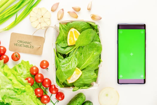 Natural vegetables and smartphone with green screen on a white background photo