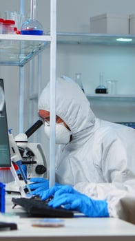 Scientists in protection suits working in chemical equipped laboratory. Team of biologists examining vaccine evolution using high tech and technology researching treatment against covid19 virus photo