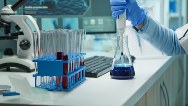 Close up of scientis testing liquid sample late at night using micropipette for medical treatment in laboratory. Team examining virus evolution using high tech for vaccine development against covid19 photo