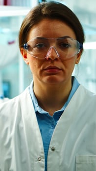 Close up of scientist nurse looking tired at camera sitting in modern equipped laboratory late at night. Team of specialists examining virus evolution using high tech for research, vaccine development photo