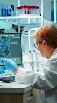 Medical research scientist typing codes on pc in biological applied science modern equipped laboratory overwork. Lab engineers conducting experiment for vaccine development against covid19 virus photo
