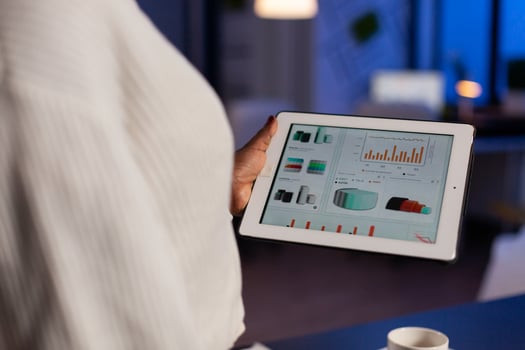 Close up of overworked black manager checking graph documents on tablet pc. Busy african employee analysing financial statistics in workplace overworking writing, searching. photo