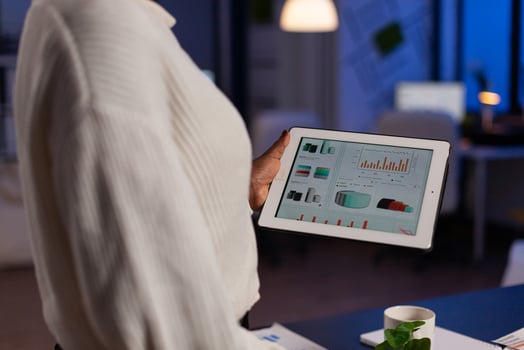 Closeup of african american entrepreneur analyzing company profit checking financial graphs reports using laptop computer. workaholic black businesswoman overworking in startup office at night photo