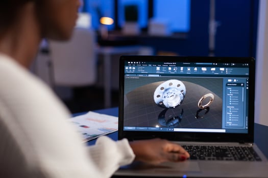 African american engineer developing engineering gear design working at industrial mechanical prototype late at night in startup company office. Project designer using industry construction software photo