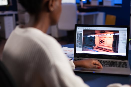 African american game developer testing new game working late at night in creativity agency company. Tired creator designer developing online games on pc using modern production technology photo