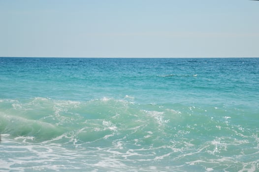 Sea, beautiful blue water with color transitions and splashes. Horizon line and clear sky. photo