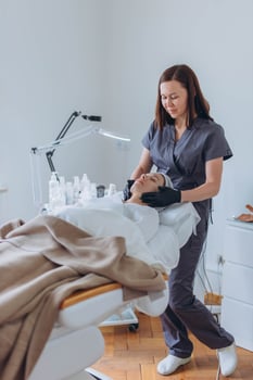 cosmetologist and client in a beauty salon doing procedures. Using a face mask photo