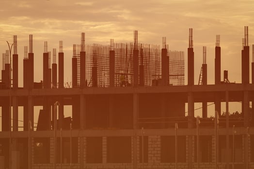 Silhouette of a team of construction workers constructing a building against the background of a sunset sky. photo