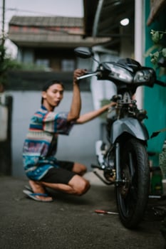 A motorcycle mechanic inspecting a damaged engine photo