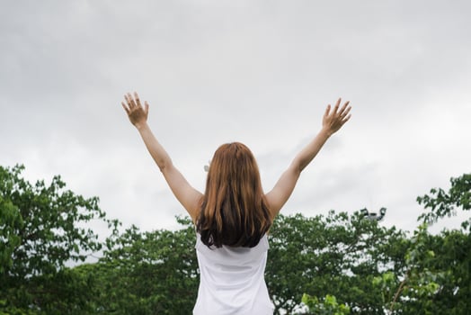 woman raised her hands above her head to ask for mercy from God in accordance with her belief in God in Christianity. back woman raising both hands to ask for blessings from God according to beliefs photo