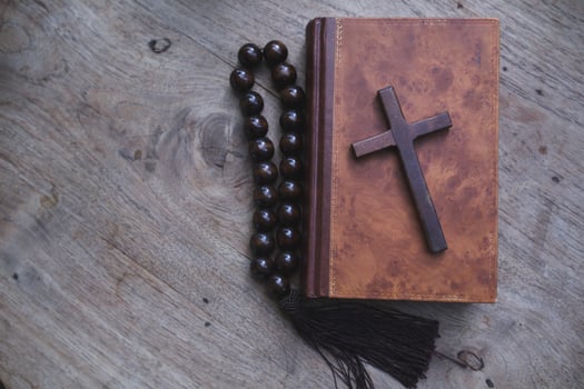 cross is placed on the Bible after prayer to God, which is religious ritual of Christianity and belief in the teachings of God. concept of praying to God with the teachings of the Bible and cross. photo