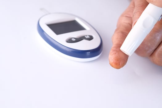 senior women with glucometer checking blood sugar level photo
