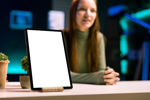 Focus on mockup tablet with gen Z teenager in blurry background doing review, comparing features. Close up shot of isolated screen portable device analyzed by influencer, filming online photo